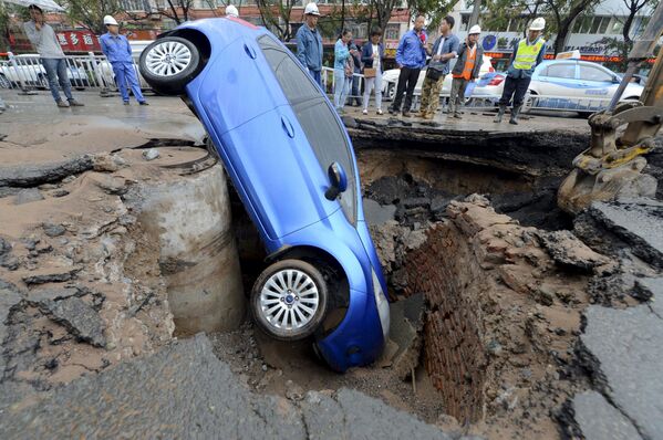 Automóvel cai em buraco na estrada na cidade chinesa de Lanzhou - Sputnik Brasil