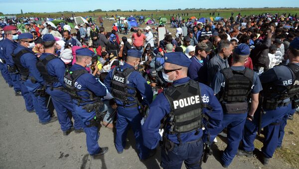 Migrantes e policiais perto da fronteira entre a Hungria e Sérvia, aldeia  Roszke, 7 de setembro de 2015 - Sputnik Brasil