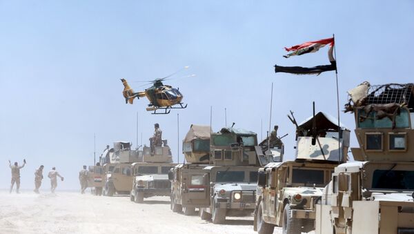 An Iraqi helicopter flies over military vehicles in Husaybah, in Anbar province July 22, 2015 - Sputnik Brasil