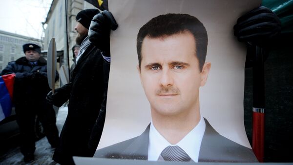 Demonstrante russo está empunhando o cartaz com a imagem do presidente sírio Bashar Assad durante uma ação de apoio proximo à embaixada síria em Moscou, 1 de fevereiro de 2012 - Sputnik Brasil