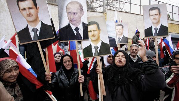 Sírios com as fotos do presidente sírio Bashar Assad e primeiro-ministro russo Vladimir Putin em Damasco - Sputnik Brasil