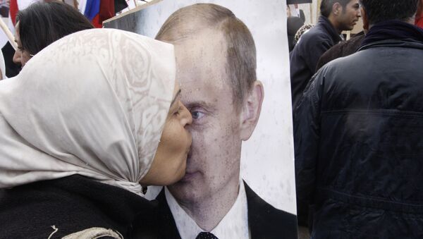 Mulher síria beija um poster do presidente russo Vladimir Putin durante uma manifestação pró-governo sírio em frente à embaixada russa em Damasco - Sputnik Brasil