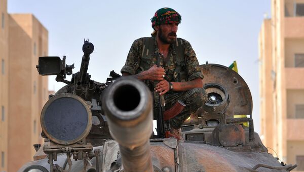 Combatente curdo senta em tanque do Exército sírio. - Sputnik Brasil