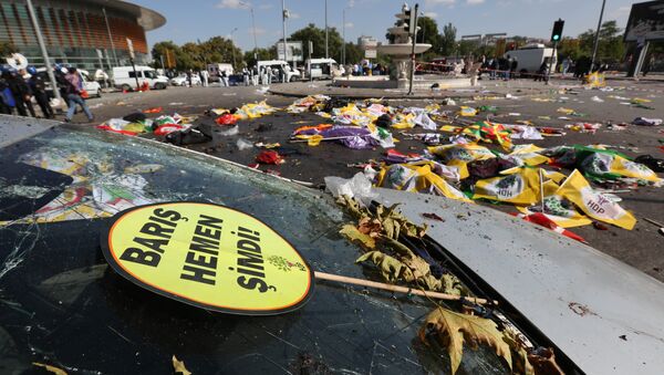 A placard that reads in Turkish: 'Peace Immediately Now' , is seen at the site of an explosion with the bodies of victims covered with flags and banners in the background, in Ankara, Turkey - Sputnik Brasil