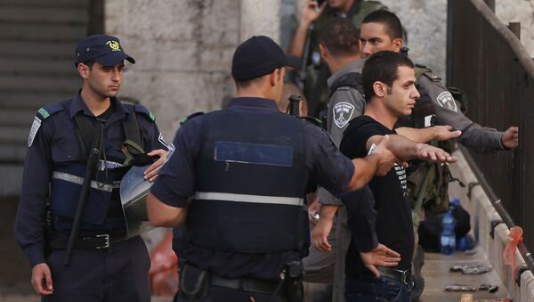 Policiais israelenses estão revistando um jovem palestiniano próximo à entrada à Cidade Antiga em Jerusalém Oriental, 13 de outubro de 2015 - Sputnik Brasil