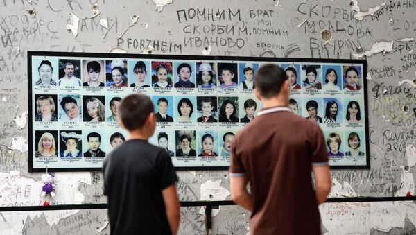 Habitantes locais perto da placa memorial no dia de cerimônia em homenagem das vítimas do atentado na escola em Beslan - Sputnik Brasil