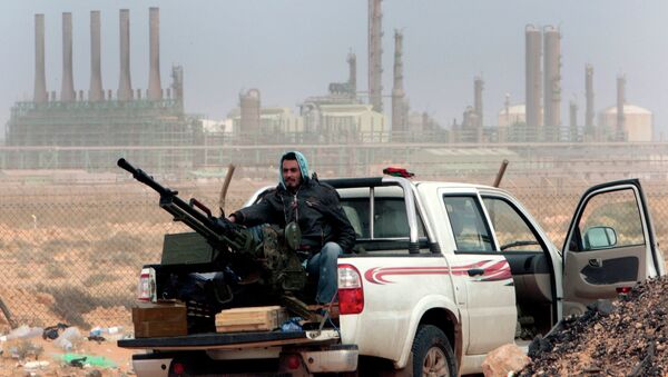 Rebelde em frente à refinaria de petróleo, após captura pelas forças opositoras ao governo da cidade de Ras Lanouf, no Leste da Líbia - Sputnik Brasil
