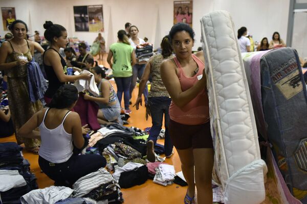 Pessoas providenciam suprimentos para evacuados na Arena Mariana, em Mariana, 124 km a sudeste de Belo Horizonte, após o rompimento de uma barragem. - Sputnik Brasil