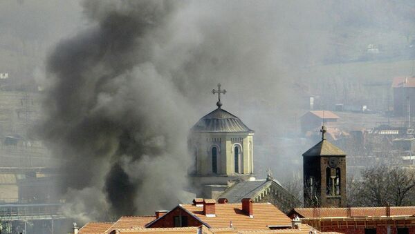 Uma coluna de fumaça sobre a Igreja Ortodoxa da Sérvia, que foi incendiada pelos extremistas da etnia albanesa em Kosovska Mitrovica, no norte de Kosovo, quinta-feira, 18 de março, 2004 - Sputnik Brasil