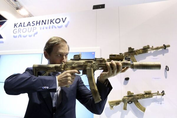 Ministro da Indústria e do Comércio da Rússia Denis Manturov com o fúsil Kalashnikov na IDEX 2015 - Sputnik Brasil