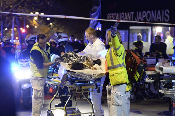 Bombeiros evacuam uma pessoa ferida da sala de concertos Bataclan perto do centro da capital francesa - Sputnik Brasil