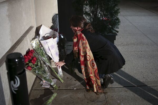 Uma mulher deposita flores na entrada do consulado da França em Nova York, depois de ouvir notícia dos atentados. - Sputnik Brasil