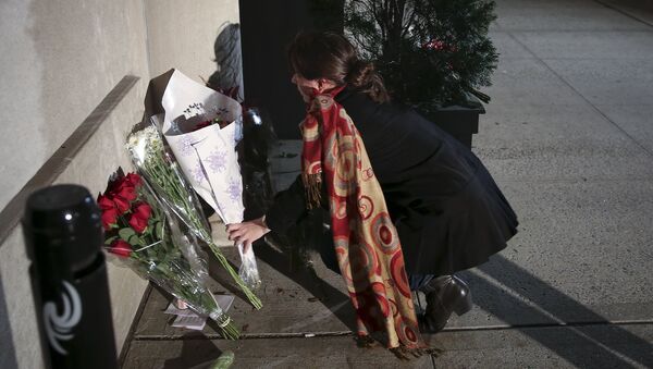 Uma mulher deposita flores na entrada do consulado da França em Nova York, depois de ouvir notícia dos atentados (foto de arquivo) - Sputnik Brasil