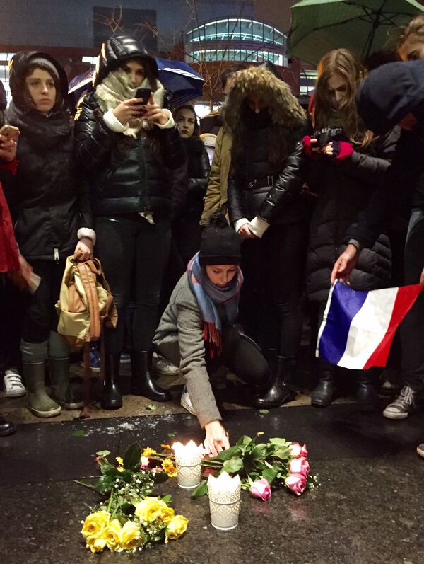 Mulher deposita flores em Montreal, Canadá, para lembrar as vítimas do atentado na França - Sputnik Brasil