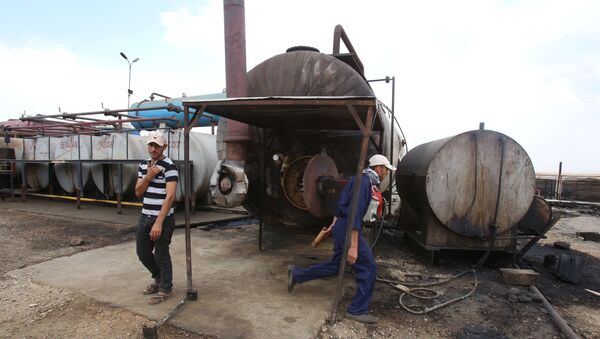 Men work on cauldron in the Rmeilane oil field in Syria's northern eastern Hasakeh province on July 15, 2015 - Sputnik Brasil