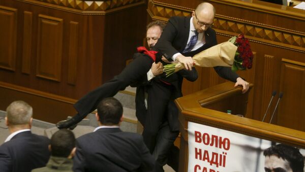 Oleg Barna, deputado da Rada, remove o primeiro-ministro Arseniy Yatsenyuk da tribuna, depois de lhe apresentar um buquê de rosas, durante a sessão do parlamento em Kiev, Ucrânia, 11 de dezembro de 2015 - Sputnik Brasil