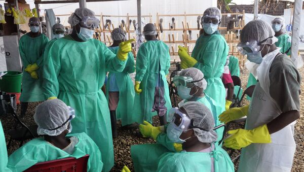 Health care workers inside a USAID-funded Ebola clinic with their Ebola virus protective gear in Liberia - Sputnik Brasil