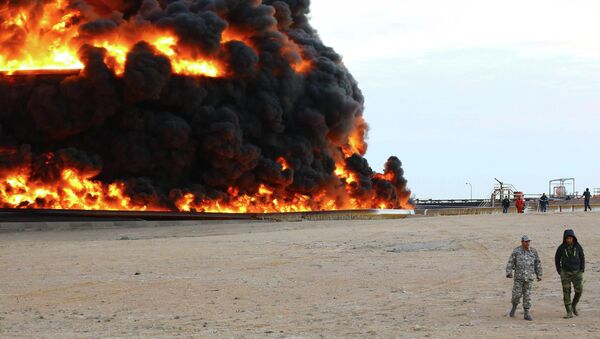 Bombeiros tentam apagar um incêndio em um tanque de petróleo no porto de Es Sider, na Líbia, em 26 de dezembro de 2014 - Sputnik Brasil