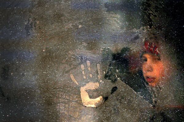Garoto observa a rua através de um vidro congelado de um ônibus em Minsk - Sputnik Brasil