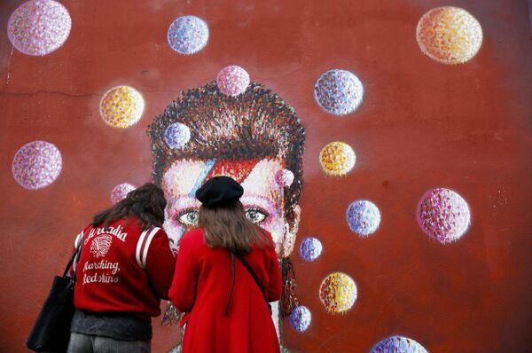 Mulheres em frente ao grafite do David Bowie em Londres - Sputnik Brasil