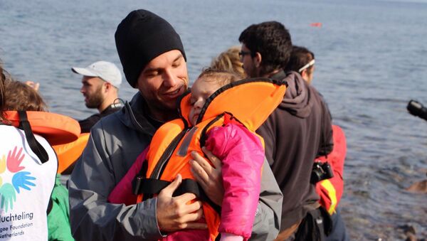 Edgard Raoul com criança refugiada desfalecida, na Ilha de Lesbos, na Grécia. - Sputnik Brasil