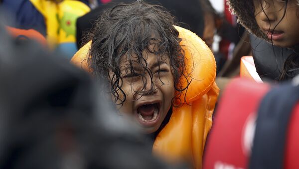 Criança refugiada da Síria grita dentro de um bote superlotado depois de atravessar parte do Mar Egeu, entre a Turquia e a ilha grega de Lesbos, 23 de setembro de 2015. - Sputnik Brasil