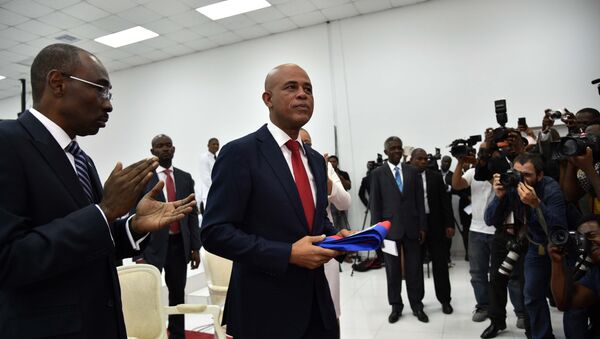 Presidente do Haiti, Michel Martelly, prepara-se para entregar a sua faixa presdiencial ao presidente da Assambleia Nacioanl do Haiti, Jocelerme Privert, durante a cerimônia no parlamento do país, 7 de fevereiro de 2016 - Sputnik Brasil