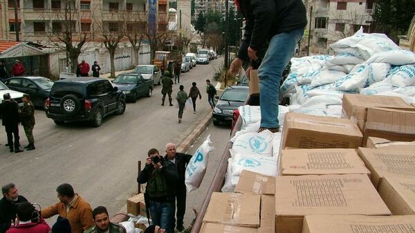Militares descargam ajuda humanitária do caminhão em uma rua da cidade de Kessab, na província síria de Latakia - Sputnik Brasil