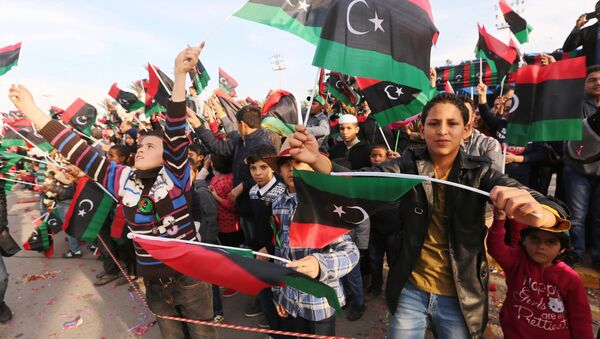 Cidadãos líbios agitam bandeiras nacionais da Líbia durante a demonstração em comemoração ao 64 aniversário de independência do país, Tripoli, Líbia, 25 de dezembro de 2015 - Sputnik Brasil