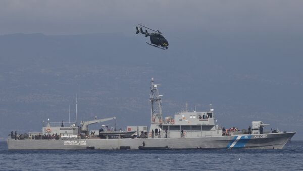 A small inflatable dinghy with a suspected smuggler on board is stopped by a Greek coastguard patrol boat, carrying migrants rescued at sea, as a helicopter from the European border control agency Frontex flies overhead, off Greece’s eastern Aegean Sea island of Lesbos on Thursday, Sept. 24, 2015 - Sputnik Brasil