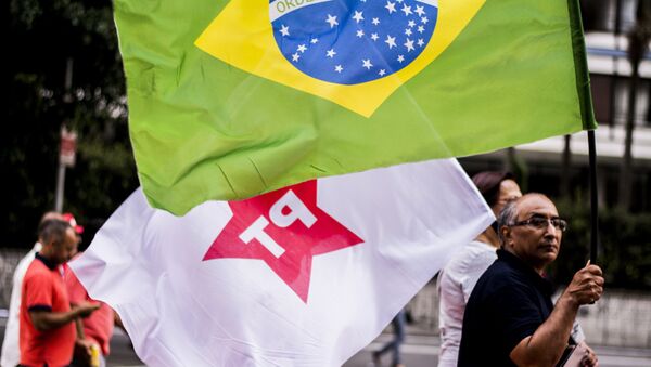 Um manifestante carrega bandeiras do PT e do Brasil no início do ato na Paulista em 18 de março de 2016 - Sputnik Brasil