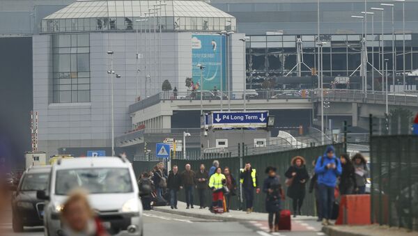 Pessoas deixam a cena de explosões no aeroporto de Zaventem, perto de Bruxelas, Bélgica, 22 de março de 2016 - Sputnik Brasil
