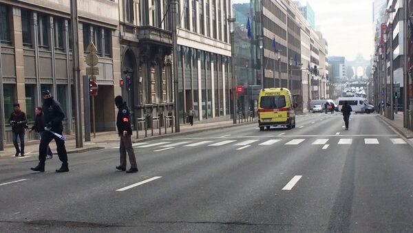 Policiais belgas e veículos de serviços de emergência na rua onde fica a entrada para a estação de metrô de Maelbeek, Bruxelas, Bélgica, 22 de março de 2016 - Sputnik Brasil