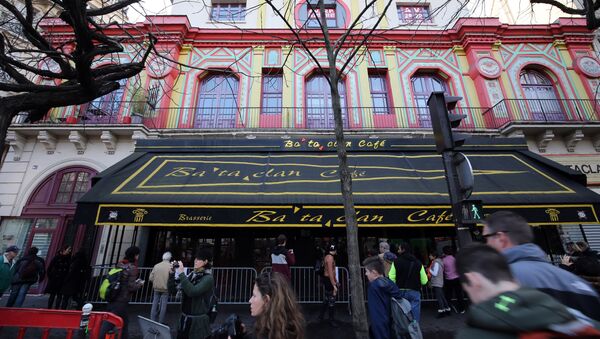 People walk past the Bataclan concert hall in Paris on December 22, 2015, after the sidewalk in front of the venue was once again made accessable to pedestrians. - Sputnik Brasil