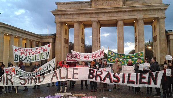 Na Alemanha, brasileiros se reúnem diante da Porta de Brandemburgo, em Berlim, estendendo cartazes com os dizeres “Não vai ter golpe” e “Pela Democracia” - Sputnik Brasil