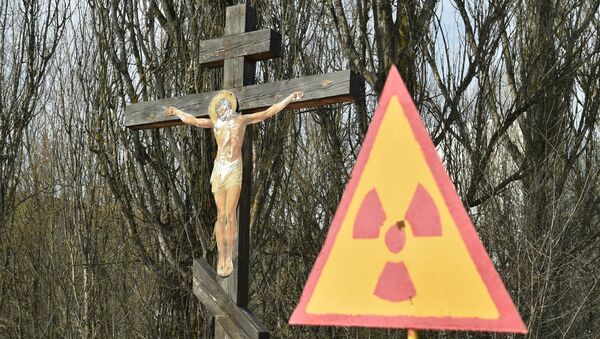 A placa indica perigo radioativo ao lado de cricifixo perto da usina nuclear de Chernobyl - Sputnik Brasil