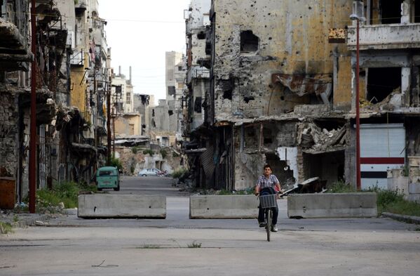 Um menino em bicicleta em uma rua na cidade síria de Homs - Sputnik Brasil