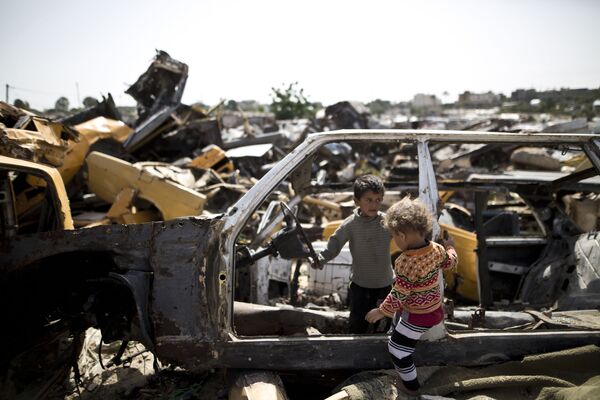Crianças palestinas brincam em um cemitério de carros na região pobre do setor de Gaza - Sputnik Brasil