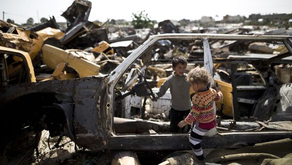 Crianças palestinas brincam em um cemitério de carros na região pobre do setor de Gaza - Sputnik Brasil