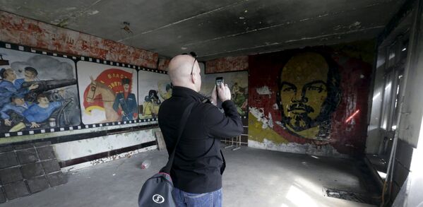 Um homem tira fotos na sala de um ginásio abandonado na cidade fantasma de Skrunda-1, Letônia, 9 de abril, 2016 - Sputnik Brasil