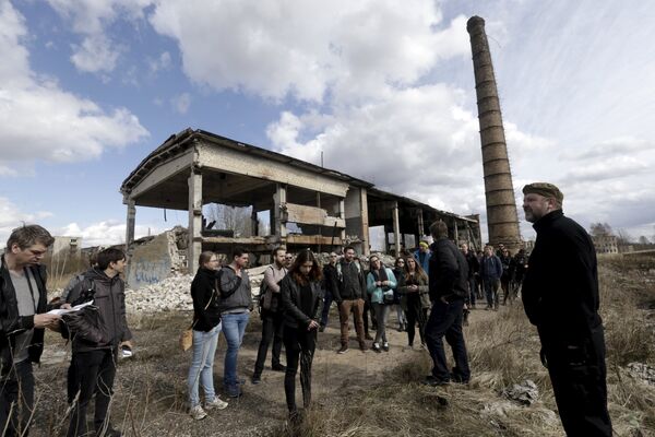 Turistas ouvem um guia (R) durante um passeio turístico na cidade fantasma sede de antiga estação soviética de radares perto da cidade de Skrunda, Letônia, 9 de abril, 2016 - Sputnik Brasil