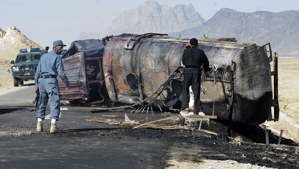 Afghan policemen stand near a burnt out fuel tanker (File) - Sputnik Brasil