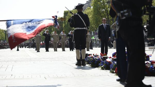 French President Francois Hollande (R) pays his respect at the Tomb of the Unknown Soldier at the base of the Arc de Triomphe during a ceremony marking the 71st anniversary of the victory over Nazi Germany during World War II on May 8, 2016 in Paris - Sputnik Brasil