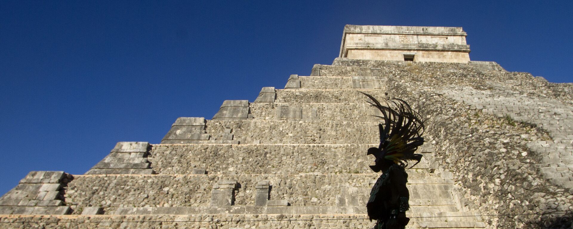 Homem vestindo traje maia passa na frente da pirâmide Kukulcan, no parque arqueológico Chichen Itzá, em 20 de dezembro de 2012 - Sputnik Brasil, 1920, 23.08.2023