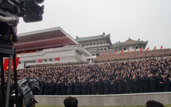 Jornalistas e pessoas presentes no centro de Pyongyang durante o desfile militar de 11 de maio saúdam o líder da Coreia do Norte, Kim Jong-un - Sputnik Brasil