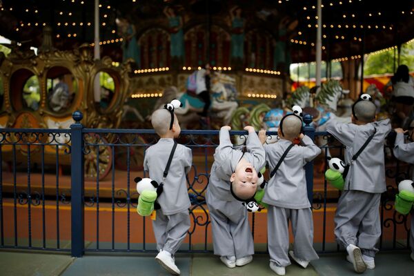 Meninos olham para um carrossel no parque de diversões Everland - Sputnik Brasil