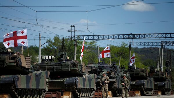 U.S. servicemen walk past U.S. M1A2 Abrams tanks as they arrive for the joint U.S.-Georgian exercise Noble Partner 2016 in Vaziani, Georgia, May 5, 2016 - Sputnik Brasil