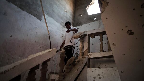 A Libyan man walks through the stairs at his house affected by heavy shelling in Sirte, Libya. - Sputnik Brasil