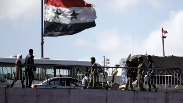 People walk near a Syrian national flag at the President bridge in Damascus - Sputnik Brasil