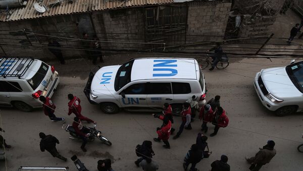UN vehicles escorting a Red Crescent convoy carrying humanitarian aid arrive in Kafr Batna, in the rebel-held Eastern Ghouta area, on the outskirts of the capital Damascus on February 23, 2016 during an operation in cooperation with the UN to deliver aid to thousands of besieged Syrians - Sputnik Brasil